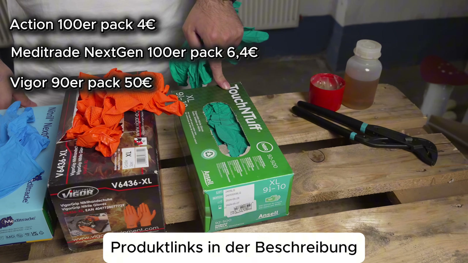 Die Verpackungen der getesteten Nitrilhandschuhe auf einer Holzpalette: Meditrade Nitril NextGen (blau), Vigor VigorGrip V6436-XL (schwarz-orange, mit orangefarbenen Handschuhen) und Ansell TouchNTuff 92-500 (grün, XL 9½–10); eingeblendete Preisliste: Action 100er 4 €, Meditrade NextGen 100er 6,40 €, Vigor 90er 50 €.