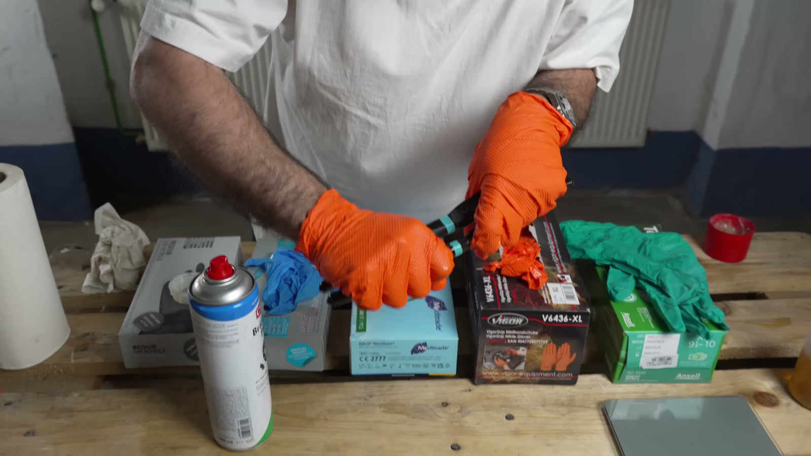 Eine mit dem Vigor-Handschuh bekleidete Hand beim Bremsenreiniger-Test; eine Spraydose ist im Bild.