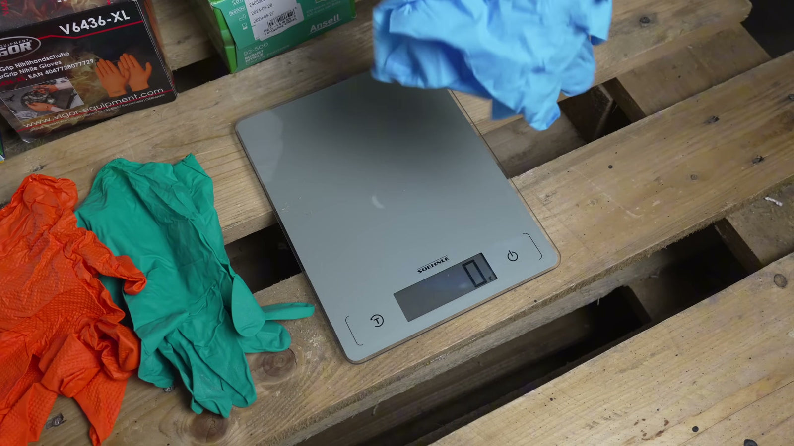 Ein einzelner Nitrilhandschuh liegt zur Wägung auf einer digitalen Waage.