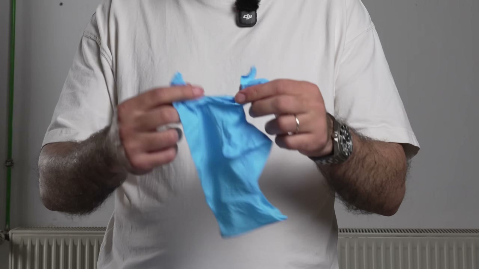 Ein Vigor-Handschuh wird im Reißtest zwischen den Fingern gedehnt.